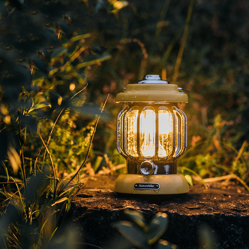 Portable camping light casting a warm glow on a campsite.